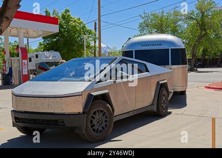 Tesla Cybertruck mit Airstream-Anhänger an einer Tankstelle im Zentrum von Moab, Utah – April 2024 Stockfoto