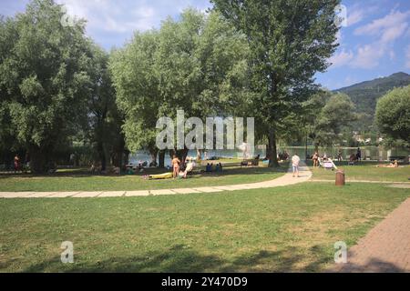 Monasterolo al Castello, Italien - August 2024 - Menschen in einem Park am Seeufer an einem sonnigen Tag Stockfoto