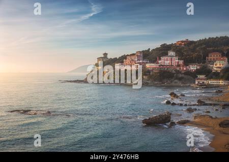 Sonnenuntergang in der Bucht von Quercetano in Castiglioncello. Felsen am Strand und Hotels an den Klippen. Provinz Livorno, Region Toskana, Italien. Stockfoto