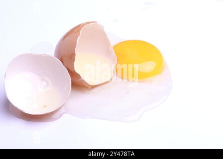 Ei mit halb geöffnetem Hintergrund auf weißem Hintergrund. Ein Ei ist kaputt. Mit Beschneidungspfad. Draufsicht Stockfoto