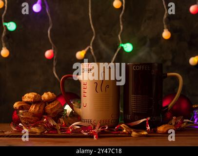 Dampfende Weihnachtskaffeetassen mit Bokeh-Lichtern. Winterferien Musik Hintergrund, gemütliches Haus Guten Morgen Konzept, Silvester festliches Lied. 2 m Stockfoto