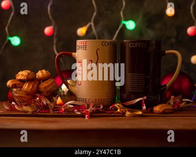 Dampfende Weihnachtskaffeetassen mit Bokeh-Lichtern. Winterferien Musik Hintergrund, gemütliches Haus Guten Morgen Konzept, Silvester festliches Lied. 2 m Stockfoto