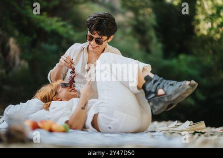 Glückliches Paar, das ein verspieltes Picknick im Park genießt Stockfoto