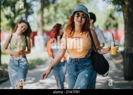 Gruppe junger Leute, die einen sonnigen Tag im Park mit Getränken und lässigen Outfits genießen Stockfoto