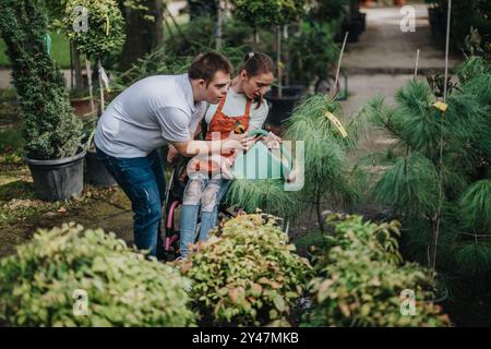 Inklusive Gartenarbeit mit jungen Mann und Frau im Rollstuhl Stockfoto