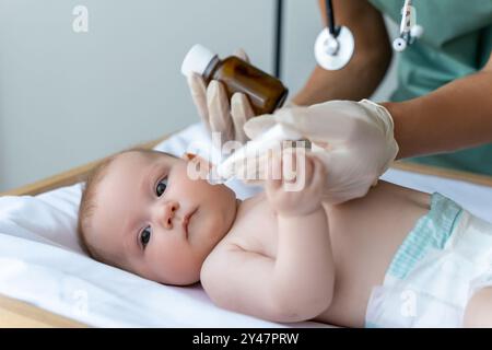 Die Krankenschwester gibt dem Neugeborenen im Krankenhauszimmer orale Heilmittel Stockfoto