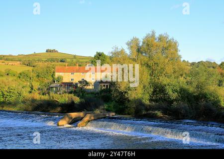 Die Brass Mills Cottages und Kelston Hill und der River Avon in Saltford bei Bristol, England, Großbritannien. Vom September 2024. Stockfoto