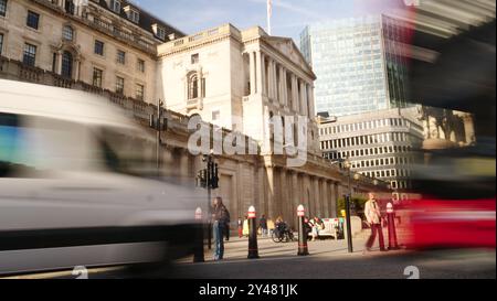 Das Gebäude der Bank of England mit Trafik und Fußgängern, die an der Bank vorbeiziehen Stockfoto