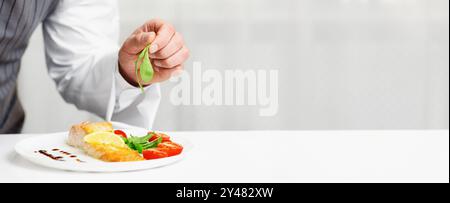 Küchenchef Galvanik Fischgericht In Der Küche Stehend, Zugeschnitten Stockfoto