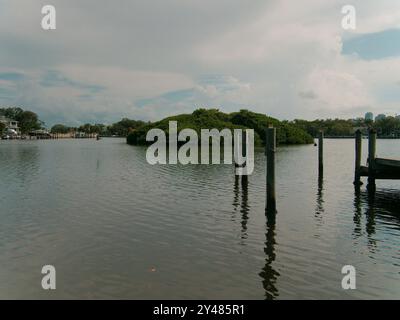 Weite Aussicht über das Wasser zum Coffee Pot Bayou Vogelschutzgebiet eine kleine Insel voller nistender Pelikane, Reiher, anderer Vögel und grüner Mangrovenbäume. Stockfoto