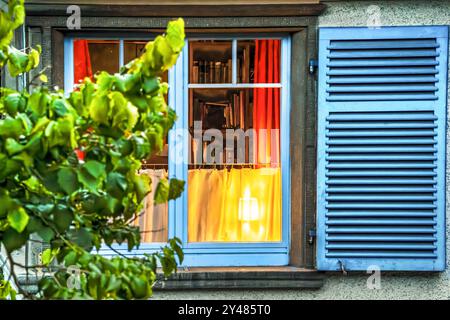 Licht leuchtet abends im Fenster, Herbstabend in Überlingen, September 2024 Deutschland, Überlingen, September 2024, Licht leuchtet abends im Fenster, Lichtschein hinter der Gardine, Dämmerung, die Tage werden kürzer, der Herbst ist da, Fensterläden offen, die Farben im Fenster sind per Zufall Schwarz-Rot-Gold, Baden-Württemberg, *** Licht leuchtet abends im Fenster, Herbstabend in Überlingen, September 2024 Deutschland, Überlingen, September 2024, Licht scheint abends im Fenster, Licht scheint hinter den Vorhängen, Dämmerung, die Tage werden kürzer, Herbst ist da, Shutte Stockfoto