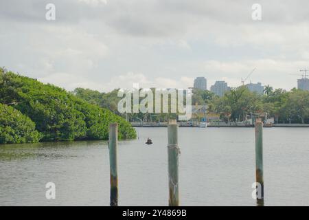 Weite Aussicht über das Wasser zum Coffee Pot Bayou Vogelschutzgebiet eine kleine Insel voller nistender Pelikane, Reiher, anderer Vögel und grüner Mangrovenbäume. Stockfoto