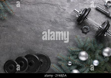 Barbell, Hantelteile und Weihnachtsdekor auf grauem Hintergrund, flache Lagen. Leerzeichen für Text Stockfoto