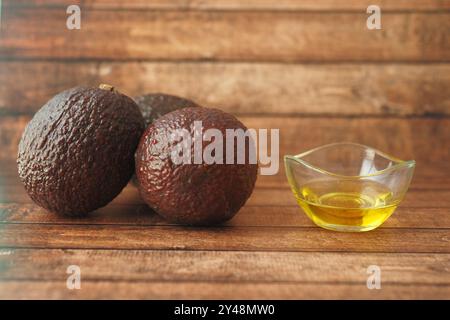 Köstliche frische Avocados und Olivenöl auf einem wunderschönen hölzernen Hintergrund zum Kochen Stockfoto