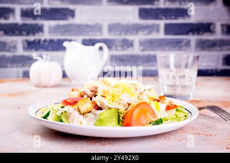 Caesar Salat mit Hühnersalat Kartoffeln Brot auf runder Platte auf hellem Hintergrund Stockfoto