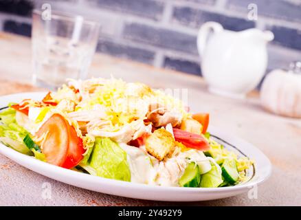 Caesar Salat mit Hühnersalat Kartoffeln Brot auf runder Platte auf hellem Hintergrund Stockfoto