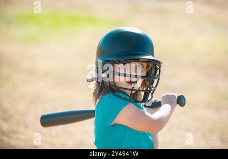 Der kleine blonde Junge mit Gesichtsausdruck hält einen Baseballschläger. Stockfoto