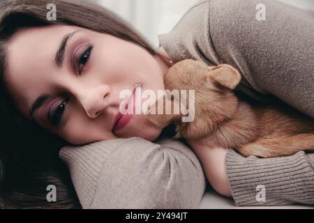 Nahaufnahme eines ruhigen Mittagsschlafens zwischen einer Frau und ihrem Welpen, der die Ruhe verkörpert Stockfoto