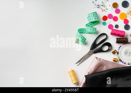 Bastelbedarf für Nähprojekte, die auf einem Tisch mit Stoff, Fäden und Werkzeugen dargestellt werden Stockfoto