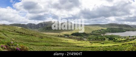 Ein Panoramablick auf Dunlewey Valley, mit den Ruinen der Dunlewey Church inmitten sanfter Hügel und üppiger grüner Landschaft in County Donegal, Irland Stockfoto