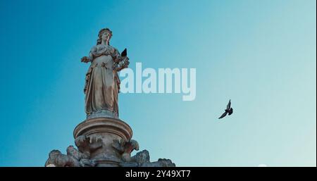 Mumbai, Indien. Die Taube Sitzt Auf Dem Flora-Brunnen. Taubenfliege Über Dem Flora-Brunnen. Der Brunnen In Hutatma Chowk Ist Mit Ornamenten Gestaltet Stockfoto