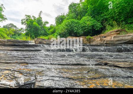 Wasserfall namens Tat Yai Wasserfall mit Gesteinsschicht und grünem Waldgrund in der lokalen Gegend namens Nam NAO District, Phetchabun, Thailand. Stockfoto