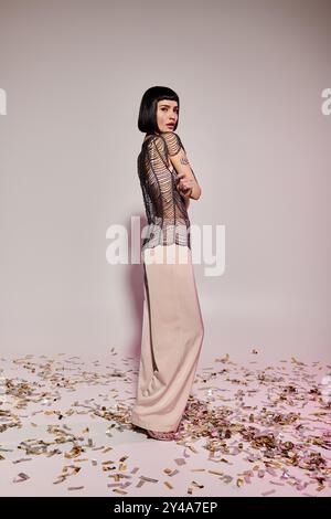 Eine junge Frau zeigt ihren Sinn für Mode mit auffälligen Tattoos und Eleganz. Stockfoto