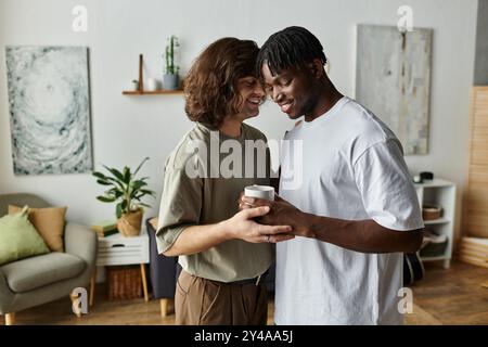 Zwei Partner verbringen einen warmen und intimen Moment miteinander, lächeln und halten eine Tasse in der Hand. Stockfoto