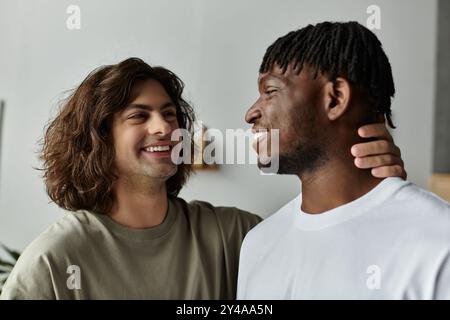 Ein liebevolles schwules Paar teilt ein Lächeln und Zuneigung in ihrem gemütlichen Zuhause und genießt einander. Stockfoto