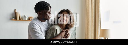 Ein liebevolles Paar teilt sich an einem ruhigen Abend mit Lachen und Wärme in seinem einladenden Wohnraum. Stockfoto