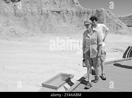 Kaukasisches Paar, 25 bis 30 Jahre alt, spaziert auf einem Wanderweg im Badlands National Park, Interior, South Dakota, USA. Stockfoto