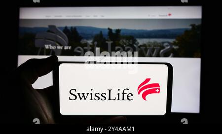 Deutschland. August 2024. In dieser Fotoabbildung hält eine Person ein Mobiltelefon mit dem Logo der Versicherungsgesellschaft Swiss Life Holding AG vor der Unternehmenswebseite. Quelle: SOPA Images Limited/Alamy Live News Stockfoto