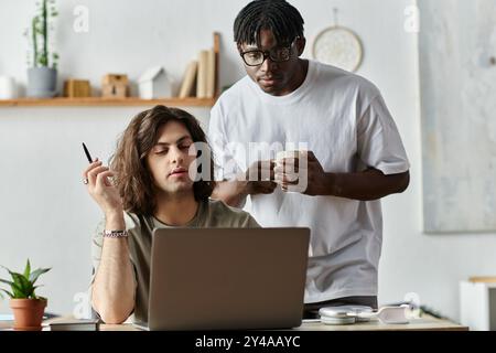 Zwei Partner verbringen einen warmen Moment zu Hause und interagieren liebevoll mit ihrem Laptop und einander. Stockfoto