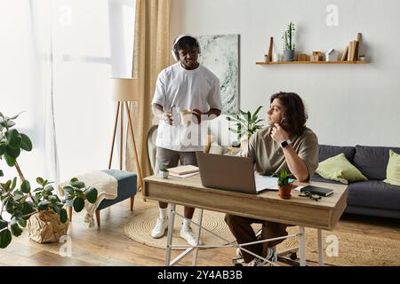 Zwei Partner teilen einen warmen Moment zu Hause, einer arbeitet fleißig, der andere unterstützt ihn. Stockfoto