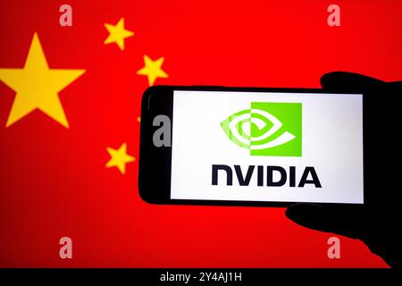 In dieser Fotoabbildung wird ein Nvidia-Logo auf einem Smartphone mit einer chinesischen Flagge im Hintergrund angezeigt. NVIDIA, ein führendes US-Technologieunternehmen, das für seine Grafikprozessoren (GPUs) und KI-Chips bekannt ist, war auf dem chinesischen Markt stark präsent. China ist einer der größten Märkte von NVIDIA, insbesondere für Rechenzentren, Spiele und Anwendungen der künstlichen Intelligenz. Aufgrund zunehmender Handelsspannungen und Bedenken hinsichtlich der nationalen Sicherheit hat die US-Regierung jedoch Beschränkungen für den Export fortschrittlicher Halbleitertechnologien auferlegt, einschließlich bestimmter High-End-NVIDIA-Chips, Stockfoto