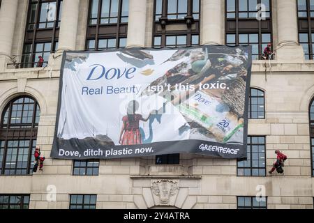 Greenpeace protestiert im Unilever-Hauptquartier in London wegen Plastikmüll. Aktivisten blockierten die Türen, während die Kletterer ein Banner zeigten. Stockfoto