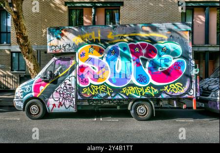 Mit Graffiti bedeckte Lieferwagen, die in der Arlington Road Camden Toen London, Großbritannien, geparkt sind Stockfoto