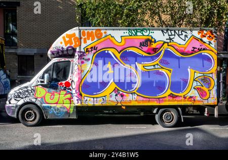 Mit Graffiti bedeckte Lieferwagen, die in der Arlington Road Camden Toen London, Großbritannien, geparkt sind Stockfoto