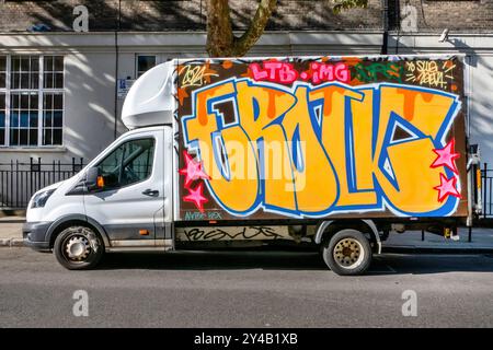 Mit Graffiti bedeckte Lieferwagen, die in der Arlington Road Camden Toen London, Großbritannien, geparkt sind Stockfoto