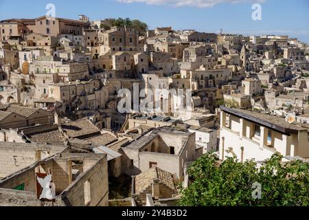 Panoramablick auf die historische Bergstadt Matera in Italien mit antiken Steinhäusern unter einem hellblauen Himmel Stockfoto