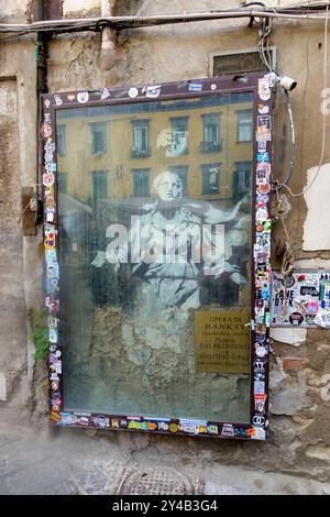 Banksy-Kunstwerk an einer Wand in Neapel, Italien, mit einem Bild der Jungfrau Maria mit einer Waffe Stockfoto