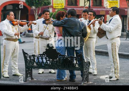 Mexiko-Stadt, Mexiko - Mariachis treten an einem Sonntagabend für ein Paar auf dem Garibaldi-Platz (Plaza Garibaldi) auf. Stockfoto