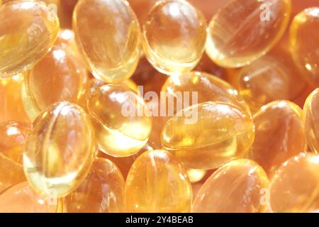 Glänzende transparente Kapseln gefüllt mit goldenem flüssigem Omega-3-Fischöl für Gesundheit und Wellness in Nahaufnahme Stockfoto