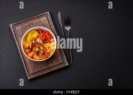 Gekochte Tigergarnelen mit Haferbrei, Tomaten und Mais auf dunklem Betonhintergrund Stockfoto