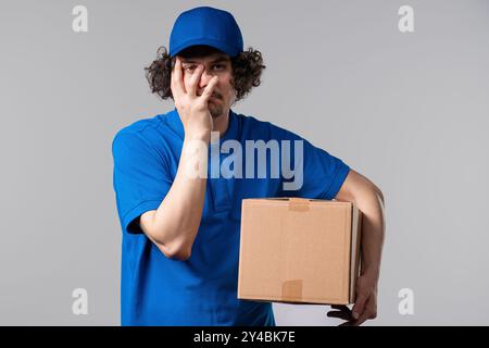 Trauriger, verwirrter Postkurier, der Facepalm macht. Trauer, Bedauern, Misserfolg Stockfoto