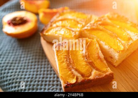 Ein Dessert aus geschnittenen Pfirsichen ist auf einem hölzernen Schneidebrett. Das Dessert ist mit Zucker bedeckt und sieht köstlich aus. Stockfoto