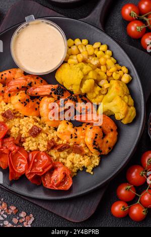 Gekochte Tigergarnelen mit Haferbrei, Tomaten und Mais auf dunklem Betonhintergrund Stockfoto