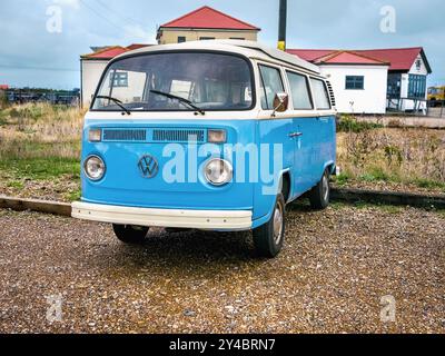 Ein klassischer blauer Volkswagen Campervan parkt in Dungeness, direkt vor dem Eisenbahnrestaurant Stockfoto