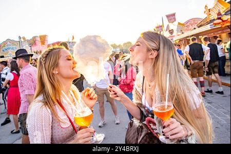 Zwei junge Frauen Freundinnen beißen gemeinsam in eine Zuckerwatte mit Aperol Spritz in der Hand auf dem Oktoberfest Wiesn in München Alkohol Spass Freude Ausgelassenheit Sonne Sonnenschein Süßes Lebensfreude Blondinen Dirndl Tracht / Datum: 21.09.2019 / *** zwei junge Freundinnen beißen zusammen zu einer Zuckerwatte mit Aperol Spritz in den Händen beim Oktoberfest Wiesn in München Alkohol Spaß Freude Ausgelassenheit Sonnenschein Sonnenschein süße Lebensfreude Sonnenschein süße Lebensfreude Lebensfreude Lebensfreude Kostüm Blondinen Blondinen Dirndl 21 09 2019 Stockfoto