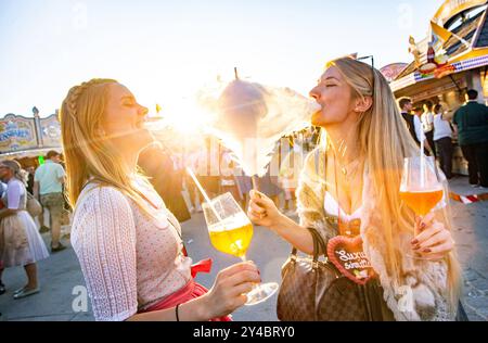 Zwei junge Frauen Freundinnen beißen gemeinsam in eine Zuckerwatte mit Aperol Spritz in der Hand auf dem Oktoberfest Wiesn in München Alkohol Spass Freude Ausgelassenheit Sonne Sonnenschein Süßes Lebensfreude Blondinen Dirndl Tracht / Datum: 21.09.2019 / *** zwei junge Freundinnen beißen zusammen zu einer Zuckerwatte mit Aperol Spritz in den Händen beim Oktoberfest Wiesn in München Alkohol Spaß Freude Ausgelassenheit Sonnenschein Sonnenschein süße Lebensfreude Sonnenschein süße Lebensfreude Lebensfreude Lebensfreude Kostüm Blondinen Blondinen Dirndl 21 09 2019 Stockfoto